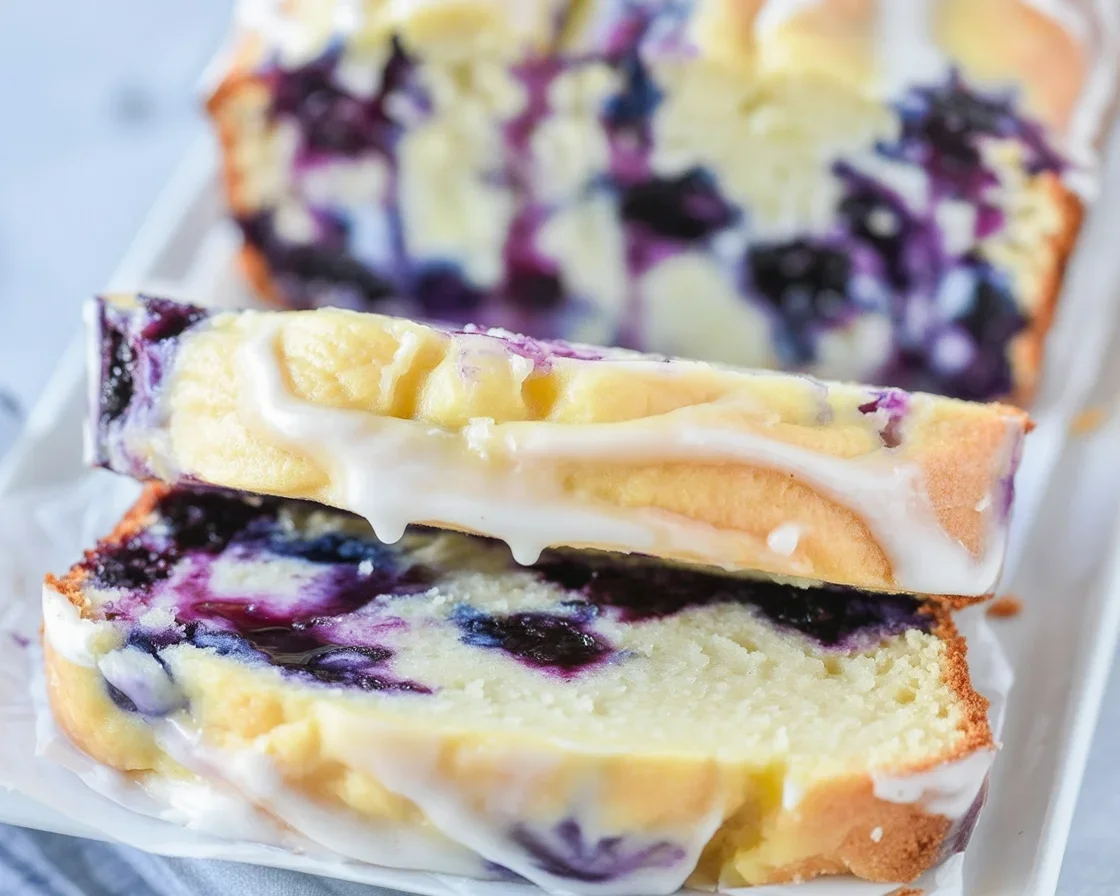 Small Batch Blueberry Lemon Loaf Cake with glaze and fresh blueberries.