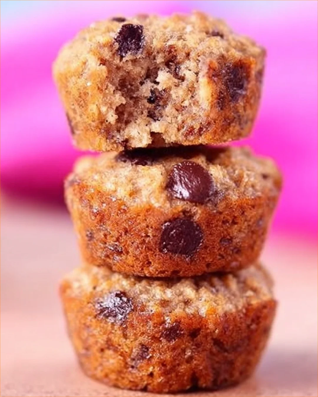 Freshly baked banana chocolate chip mini muffins on a cooling rack