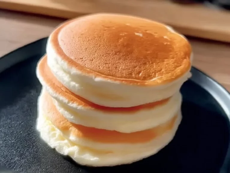 Fluffy cloud-like pancakes stacked on a plate with syrup and berries
