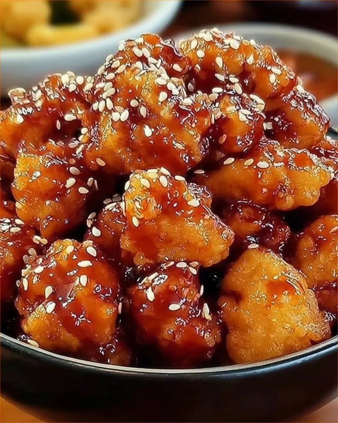 Crispy Baked Orange Chicken garnished with green onions and sesame seeds