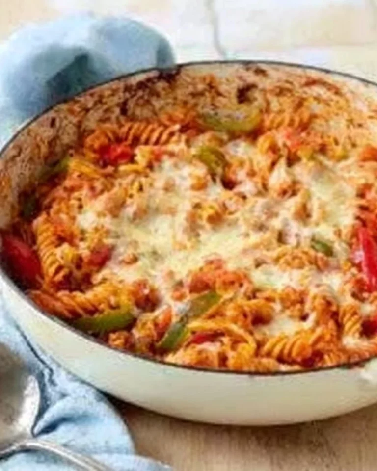 One pot chicken fajita pasta bake in a baking dish with colorful peppers and chicken.