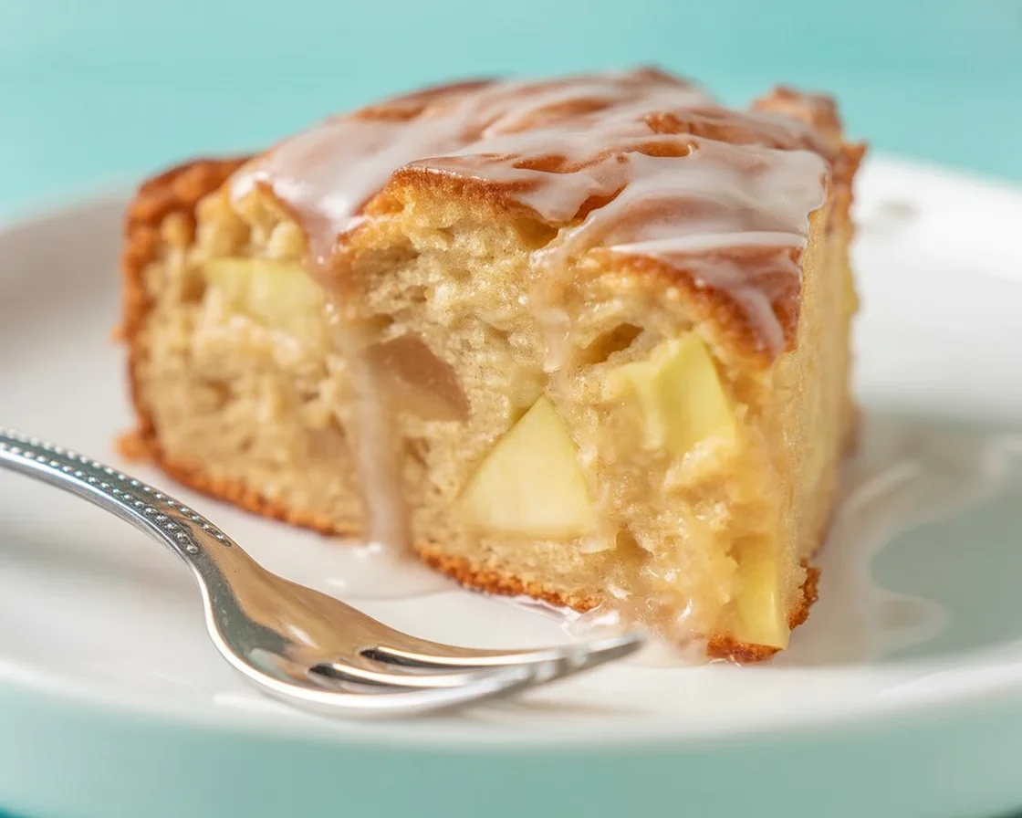 A slice of Small Batch Apple Cake topped with cinnamon and fresh apples.
