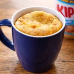 Flourless Peanut Butter Mug Cake (No Sugar) served in a mug with melting chocolate chips.
