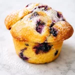 Freshly baked small-batch oat flour blueberry muffins topped with blueberries.