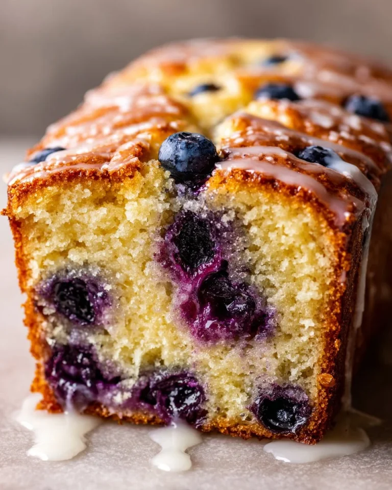 Lemon blueberry loaf cake topped with fresh blueberries and lemon zest
