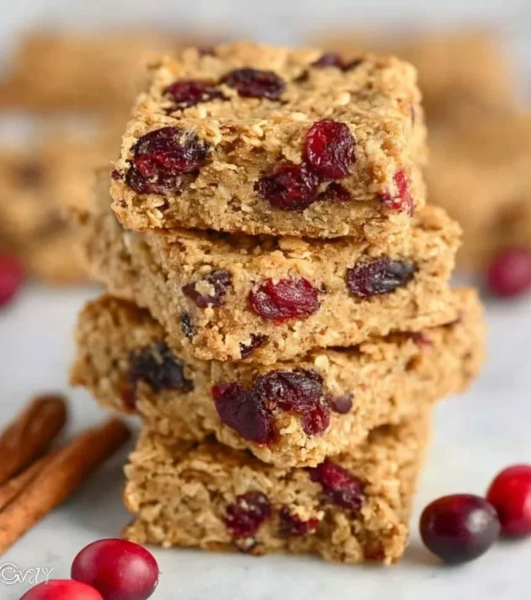 Homemade cranberry oatmeal bars with a golden brown top and cranberries visible