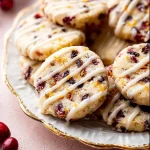 Cranberry orange icebox cookies on a plate, featuring a vibrant citrus color.