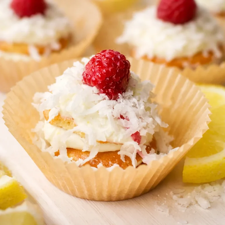 Mini Lemon Coconut Icebox Cups topped with coconut and fresh lemon slices in paper cups.