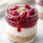 Healthy Raspberry Chia Cheesecake Jars served in mini mason jars with fresh raspberries.